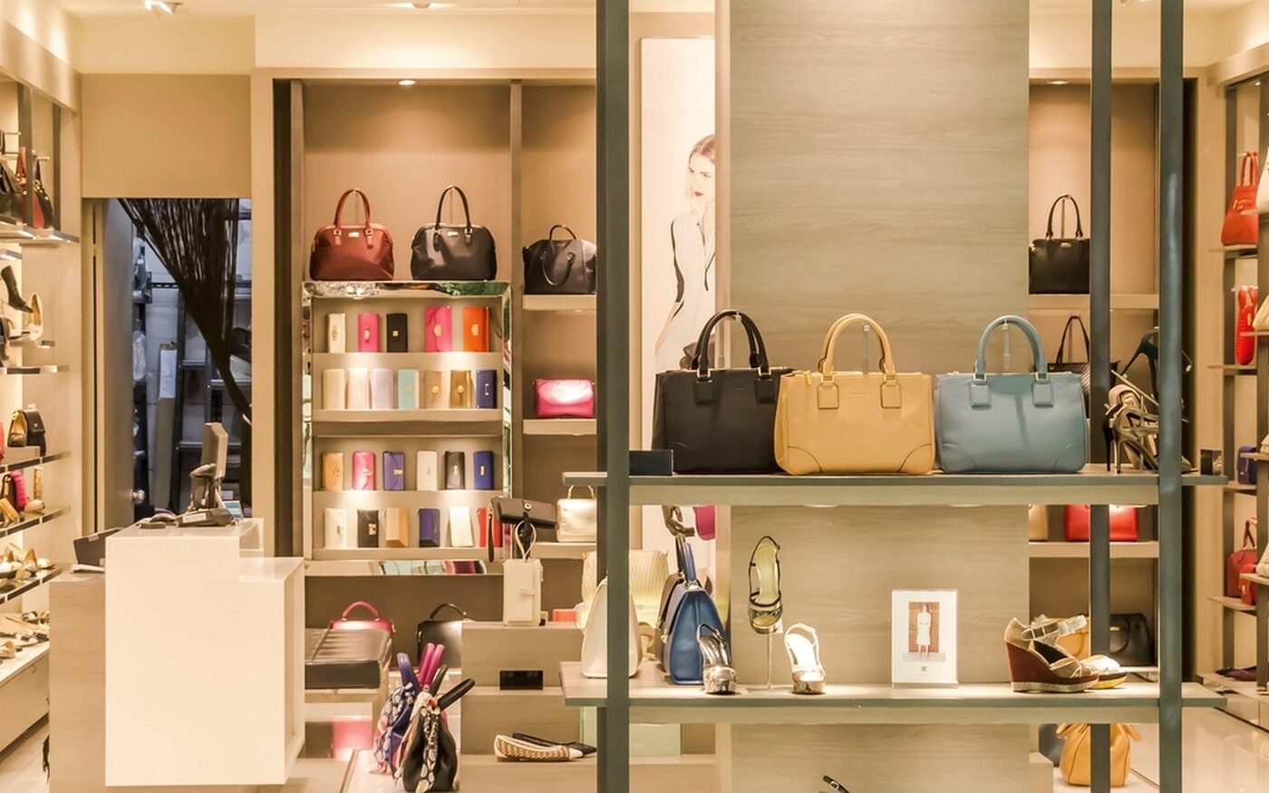 Handbags and shoes on the lit shelves of a boutique