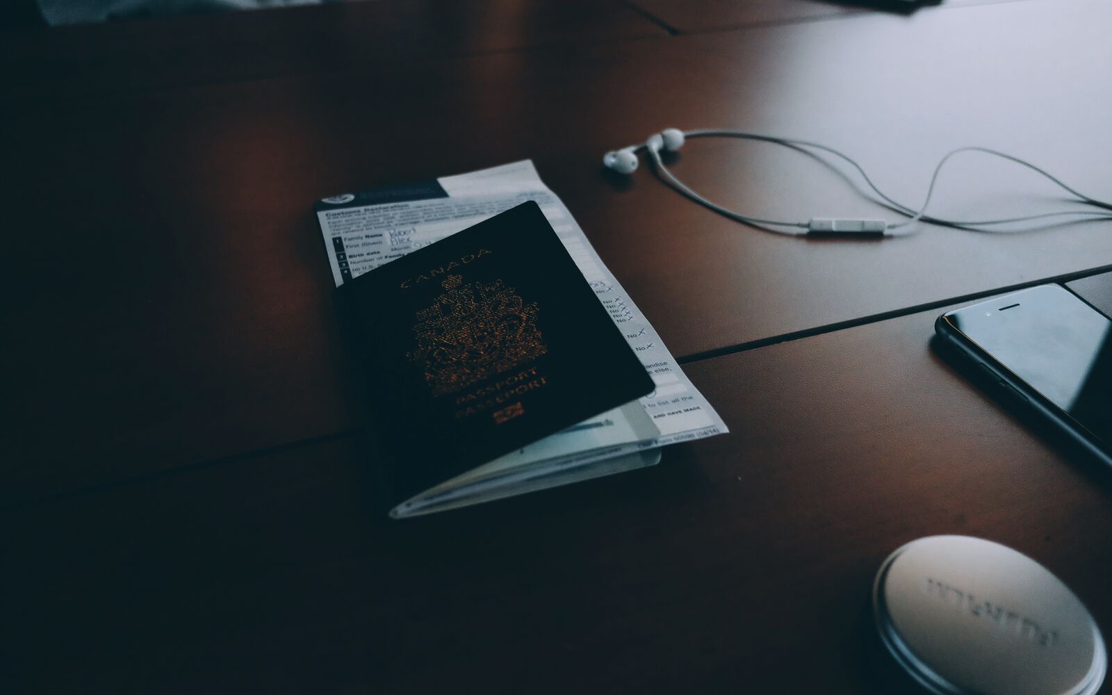 A passport and travel papers on a dark desk